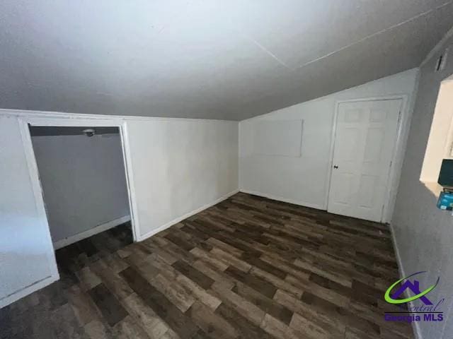 bonus room featuring lofted ceiling and dark wood-type flooring