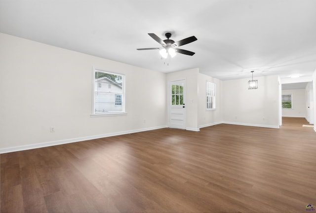 unfurnished living room with a healthy amount of sunlight, dark hardwood / wood-style floors, and ceiling fan