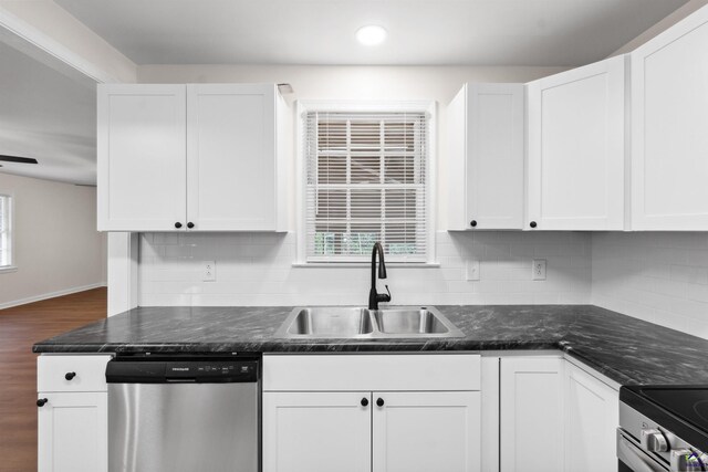 kitchen featuring appliances with stainless steel finishes, white cabinetry, backsplash, dark hardwood / wood-style floors, and sink