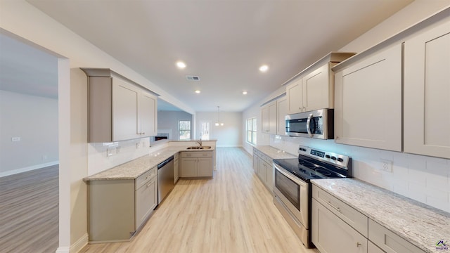 kitchen featuring gray cabinets, light hardwood / wood-style floors, appliances with stainless steel finishes, and sink