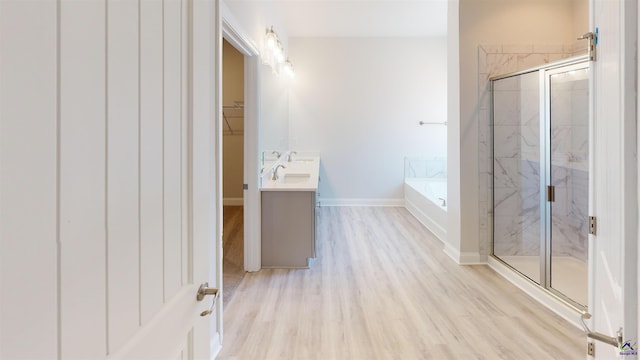 bathroom with shower with separate bathtub, hardwood / wood-style floors, and vanity