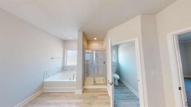 bathroom with wood-type flooring, separate shower and tub, and toilet