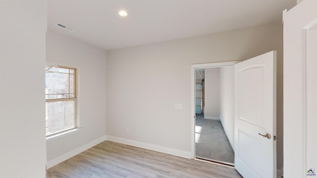 empty room with plenty of natural light and light hardwood / wood-style floors