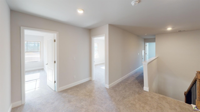 hallway featuring light carpet