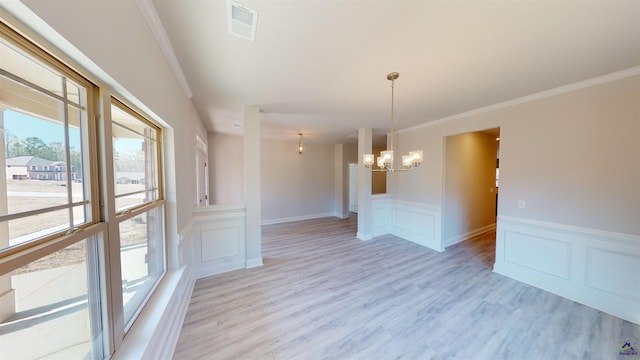 unfurnished room featuring light hardwood / wood-style floors, ornamental molding, and a notable chandelier