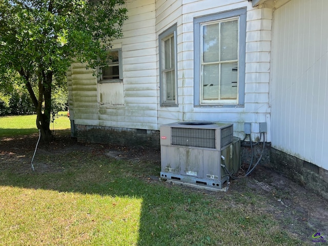 exterior space with central AC unit and a yard