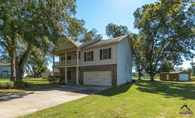 view of front of property featuring a garage, a front yard, and a balcony