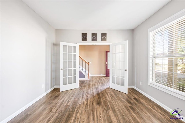 spare room featuring french doors and dark hardwood / wood-style floors