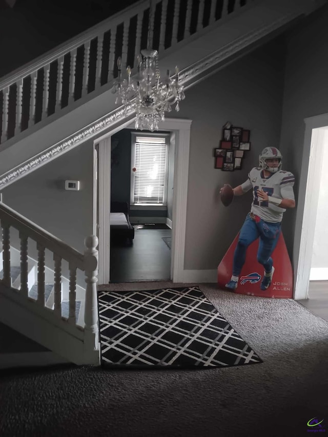 carpeted foyer with vaulted ceiling and an inviting chandelier