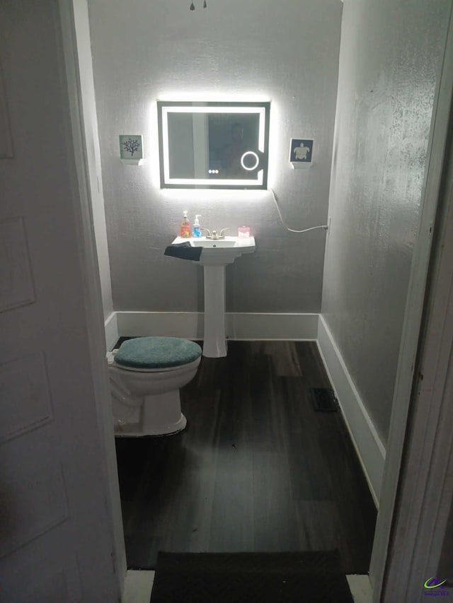 bathroom with wood-type flooring and toilet