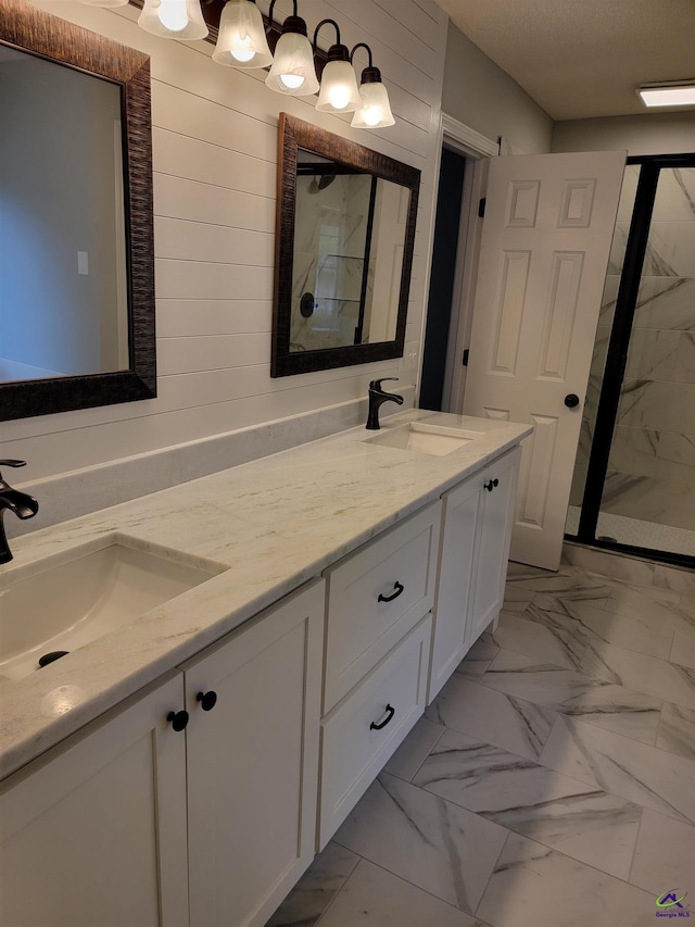bathroom featuring a shower stall, marble finish floor, and a sink
