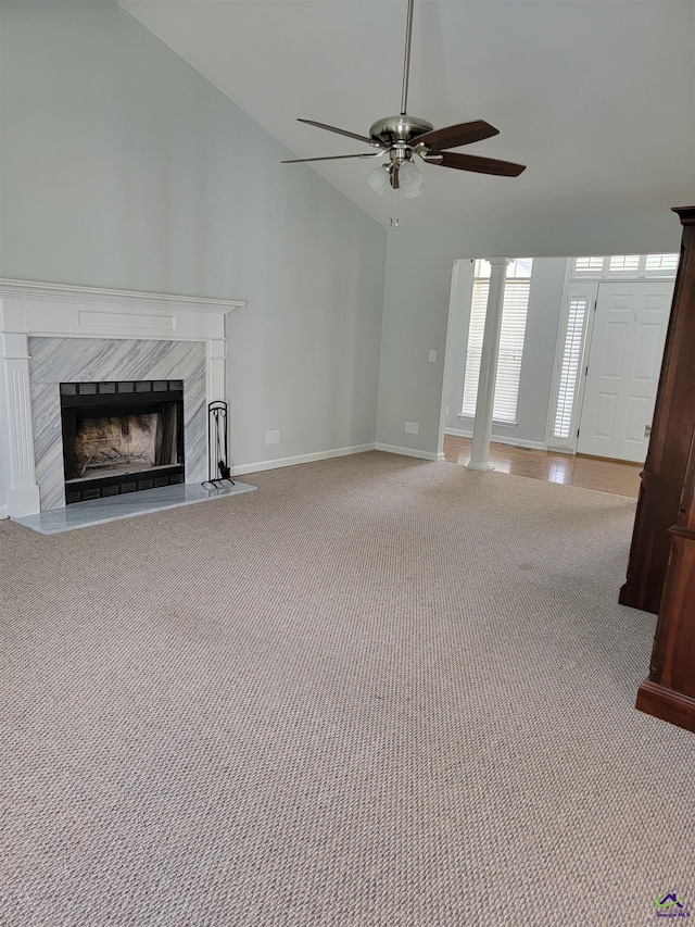 unfurnished living room featuring baseboards, a ceiling fan, carpet, a high end fireplace, and lofted ceiling