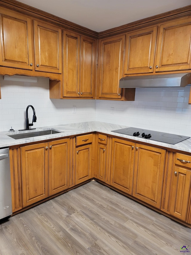 kitchen featuring brown cabinetry, dishwasher, and a sink