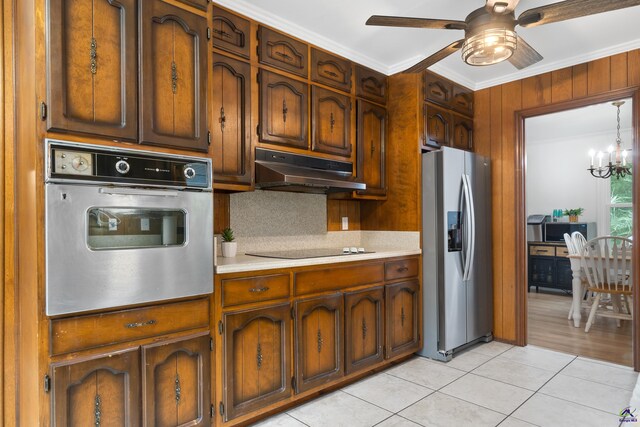 kitchen featuring hanging light fixtures, light tile patterned floors, appliances with stainless steel finishes, crown molding, and decorative backsplash