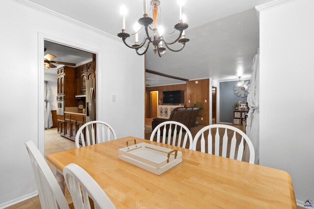 dining area with wooden walls, a chandelier, light hardwood / wood-style floors, and crown molding