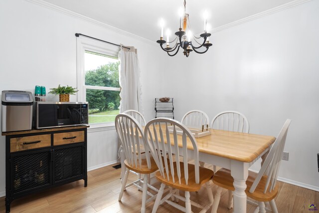 dining room featuring an inviting chandelier, light hardwood / wood-style flooring, and ornamental molding