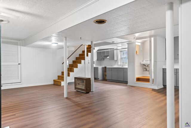 unfurnished living room with a textured ceiling, hardwood / wood-style flooring, and sink