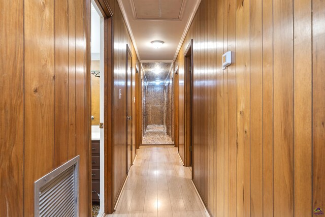 corridor featuring light hardwood / wood-style flooring and crown molding