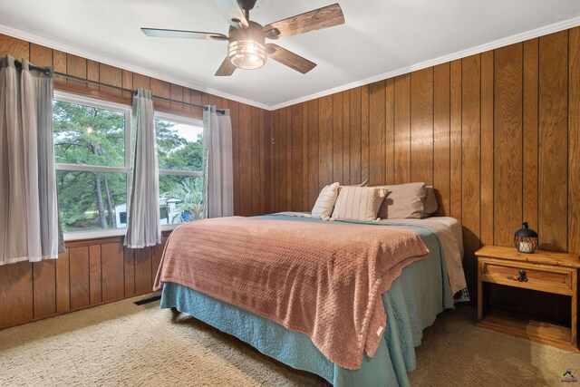 bedroom featuring carpet floors, crown molding, wood walls, and ceiling fan