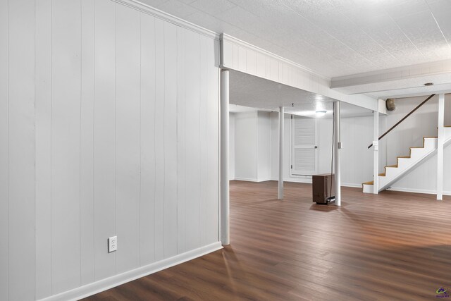 basement with wood-type flooring and wood walls