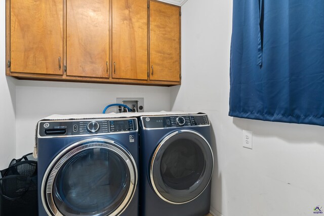 laundry area featuring washing machine and clothes dryer and cabinets