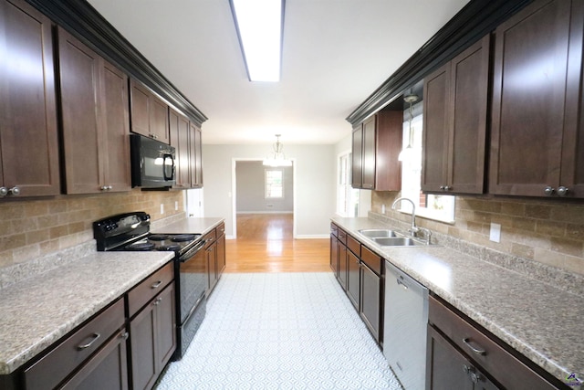 kitchen featuring black appliances, a sink, baseboards, decorative backsplash, and light wood-style floors
