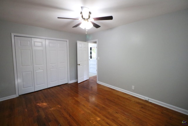 unfurnished bedroom with wood finished floors, baseboards, a closet, and a ceiling fan
