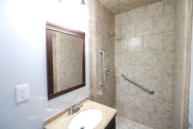 bathroom featuring a tile shower and vanity