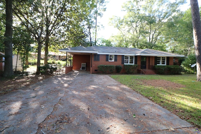 ranch-style home featuring driveway, brick siding, a carport, and a front yard