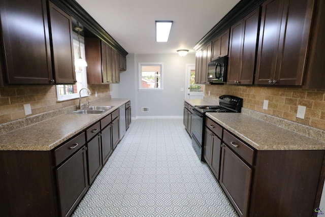 kitchen featuring black appliances, a sink, baseboards, and dark brown cabinetry