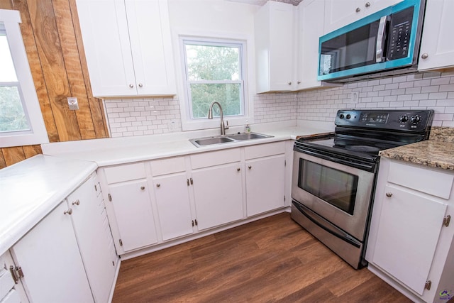 kitchen featuring appliances with stainless steel finishes, sink, dark wood-type flooring, and white cabinets