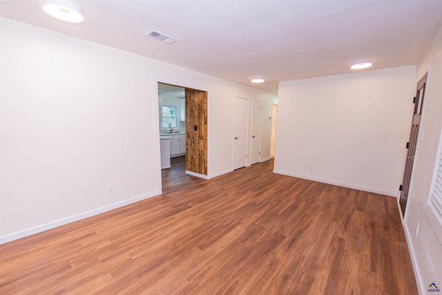 unfurnished room featuring wood-type flooring and sink