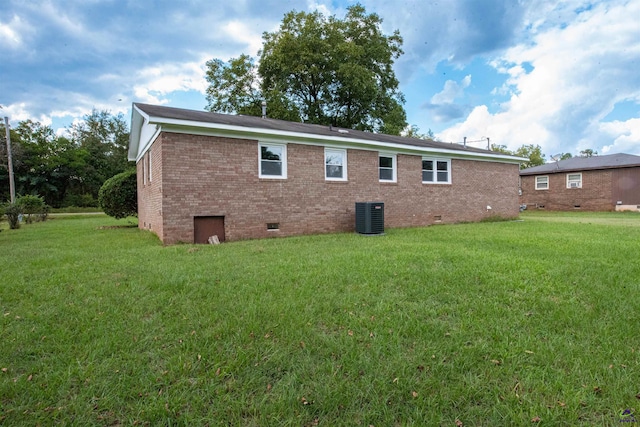 rear view of house with a yard and central AC