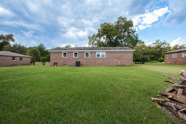 back of house featuring a lawn and central air condition unit