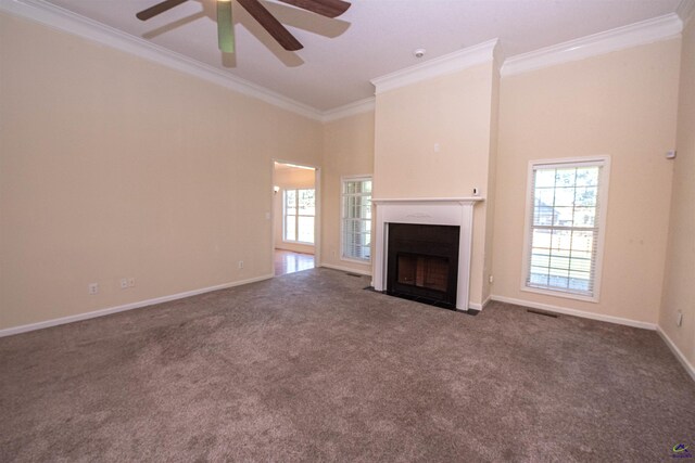 unfurnished living room with ceiling fan, ornamental molding, carpet floors, and a towering ceiling