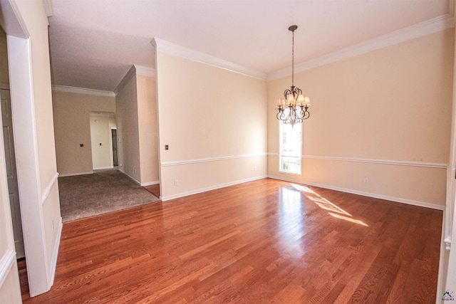 spare room with wood-type flooring, ornamental molding, and a chandelier