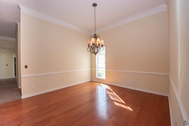 empty room with hardwood / wood-style floors, an inviting chandelier, and ornamental molding