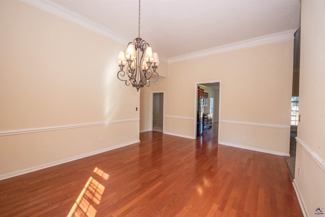 unfurnished room featuring wood-type flooring, ornamental molding, and a notable chandelier