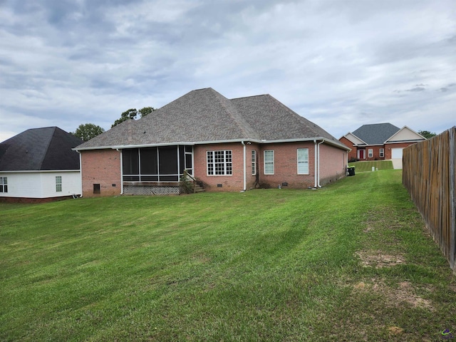 rear view of house with a sunroom and a yard