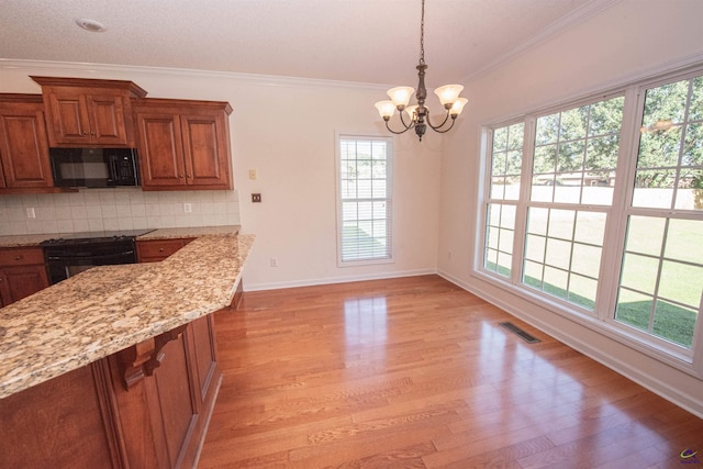 kitchen featuring light stone countertops, a notable chandelier, crown molding, black appliances, and light wood-type flooring