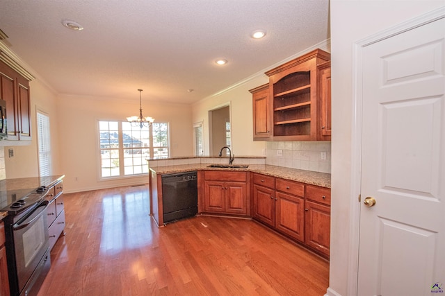 kitchen with black appliances, sink, hardwood / wood-style flooring, decorative light fixtures, and kitchen peninsula