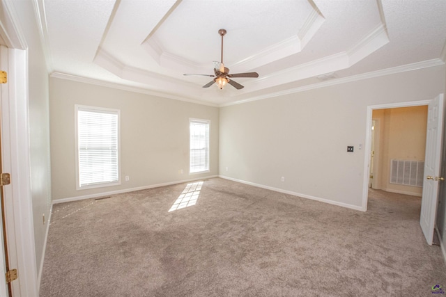 unfurnished room featuring a tray ceiling, crown molding, ceiling fan, and light colored carpet