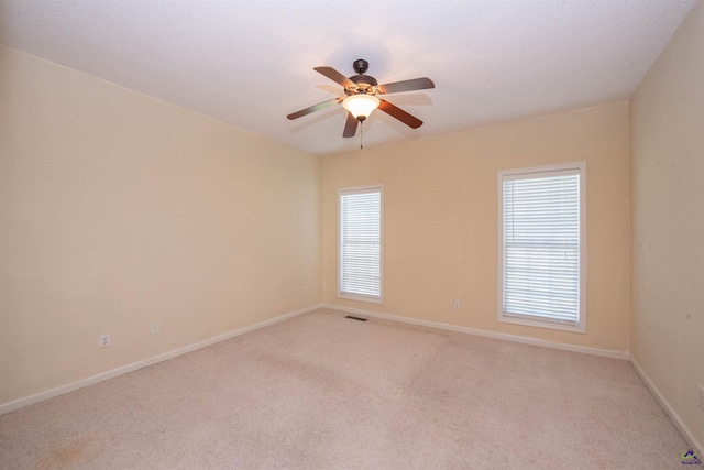 carpeted spare room with ceiling fan