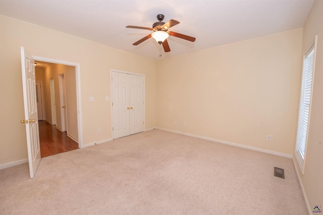 unfurnished bedroom with ceiling fan and light carpet