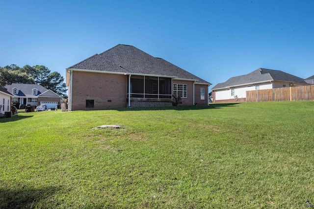 rear view of property with a sunroom and a yard