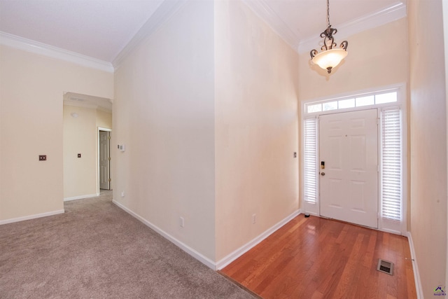 entryway with hardwood / wood-style floors and ornamental molding