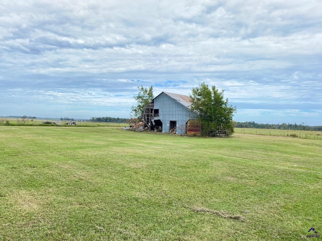 view of yard with an outbuilding and a rural view