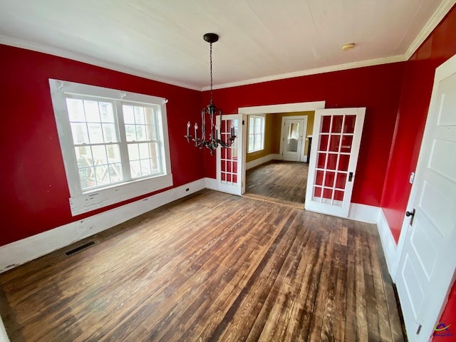 unfurnished dining area with an inviting chandelier, crown molding, dark hardwood / wood-style flooring, and a wealth of natural light