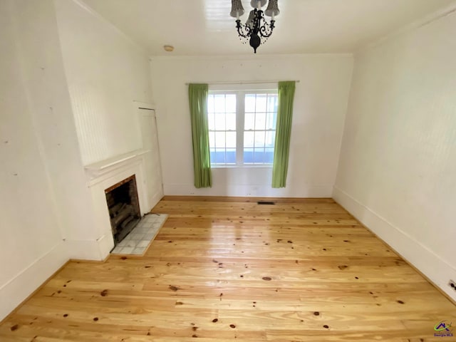 interior space featuring ornamental molding, light hardwood / wood-style flooring, and a notable chandelier