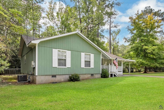 manufactured / mobile home featuring cooling unit, covered porch, and a front yard